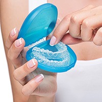 Person placing clear aligners in protective case