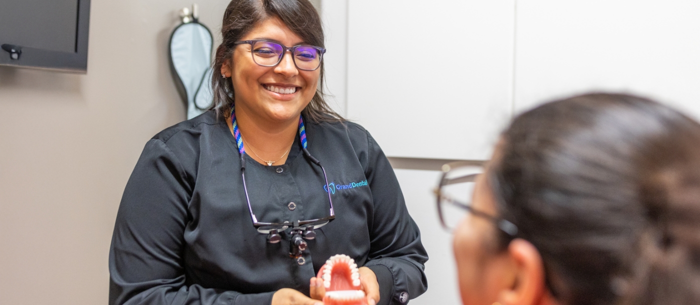 Dentist smiling while talking to patient