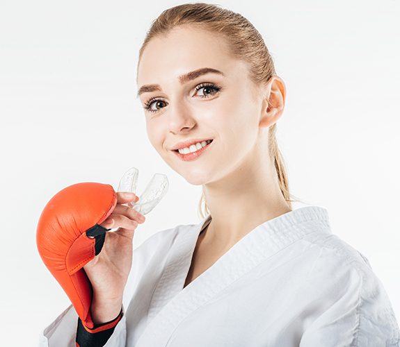 girl in boxing clothes holding mouthguard