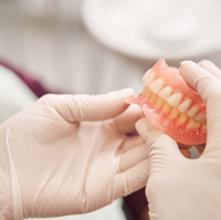 Dentist holding a full set of dentures