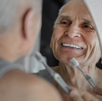 Older man smiling in the mirror