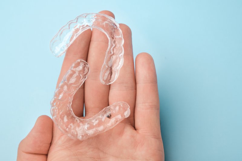 set of clear aligners in the palm of a hand 