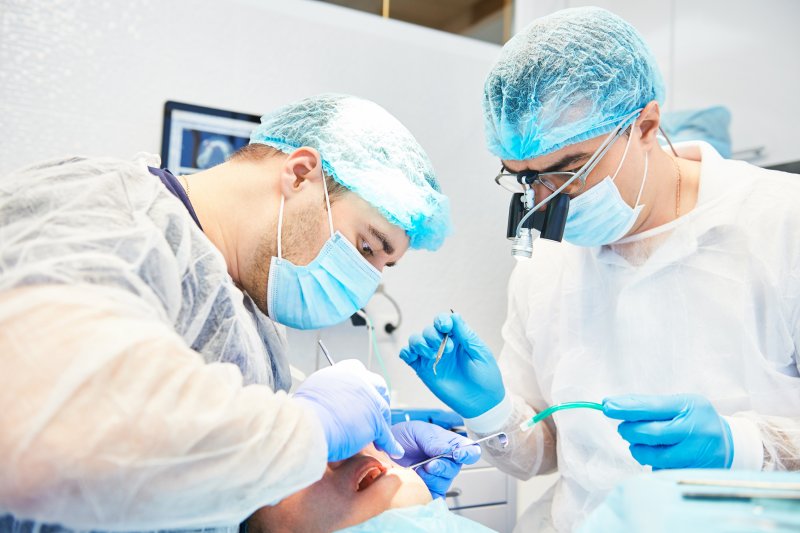 dentists performing dental implant surgery